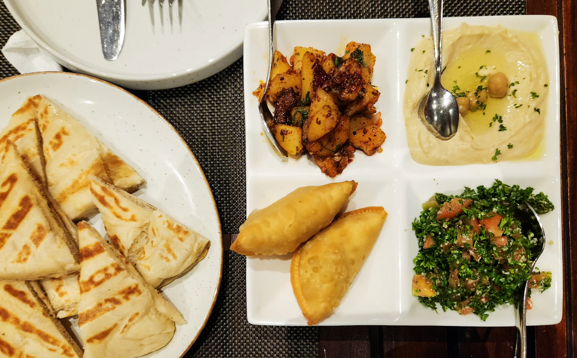 Frisch zubereitete orientalische Mezze-Platte mit Hummus, gegrilltem Gemüse und warmem Fladenbrot